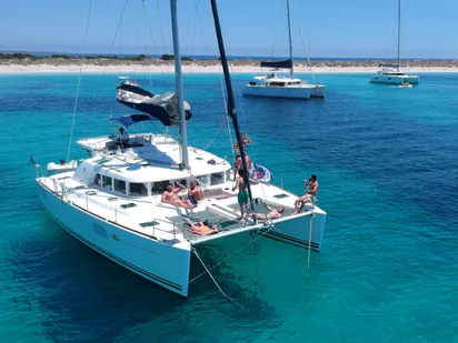 Guests relaxing on the bow trampoline nets of the Lagoon 440 with cocktails at golden hour