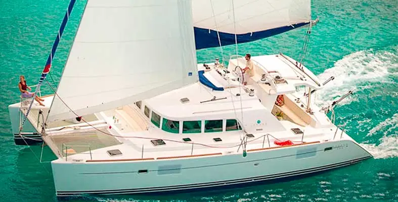 Lagoon 440 flybridge seating with guests enjoying sunset cocktails and a USCG captain at the helm